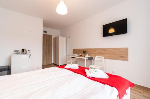 a bedroom with a bed with a red blanket on it at Willa Wena in Ustka