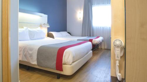 duas camas num quarto de hotel com uma janela em Holiday Inn Express Madrid-Alcorcón, an IHG Hotel em Alcorcón