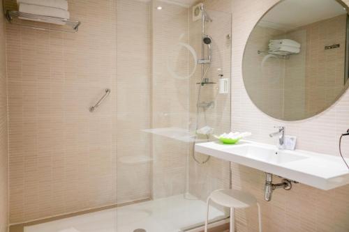a bathroom with a shower and a sink and a mirror at Hotel Opera in Madrid