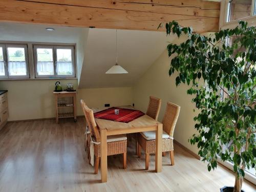 a dining room with a wooden table and chairs at Ferienhaus Scholz in Rieden am Forggensee