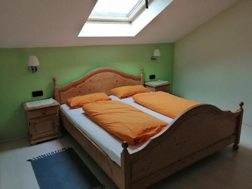 ein Schlafzimmer mit einem Bett mit orangefarbener Bettwäsche und einem Fenster in der Unterkunft Ferienhaus Scholz in Rieden