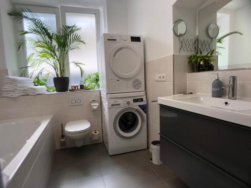 ein Badezimmer mit einer Waschmaschine und einem Waschbecken in der Unterkunft AM City Apartment 24h Self-Check-In, Free Parking, U-Bahn 350m, Netflix in Nürnberg