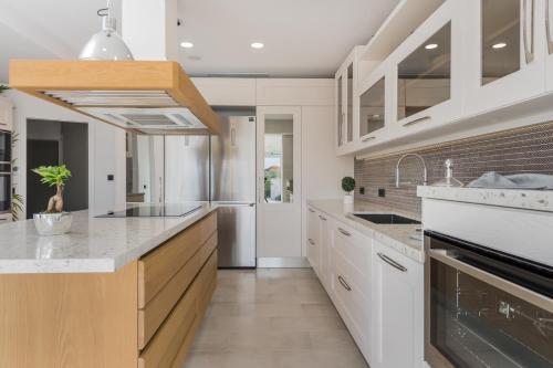 a kitchen with white cabinets and a counter top at Villa Shangri-La Zakinthos in Zakynthos Town