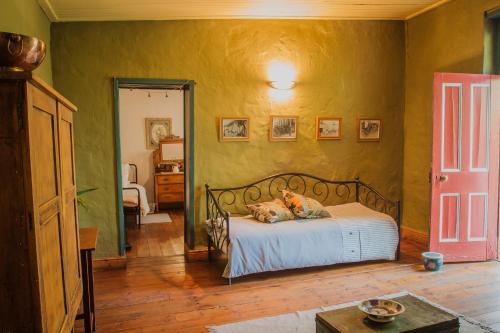 a bedroom with a bed with a dog laying on it at Bo Kapie(1833) in Swellendam