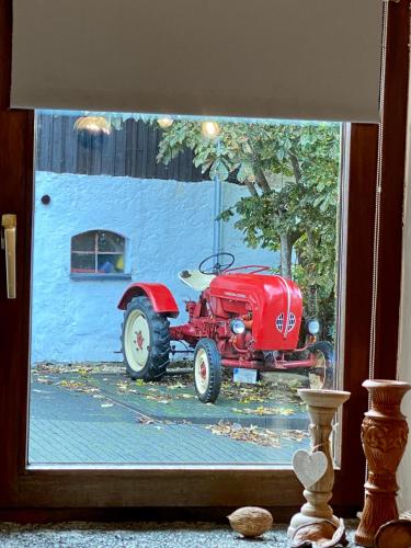 a window with a picture of a red tractor at Eifelstein, Apartment mit Whirlpool und Ofen in Dahlem