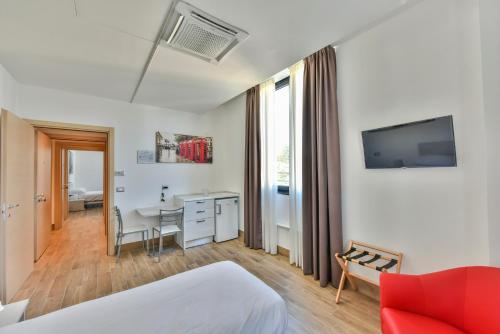 a hotel room with a bed and a desk at Happy Residence Milano Cesano Maderno in Cesano Maderno