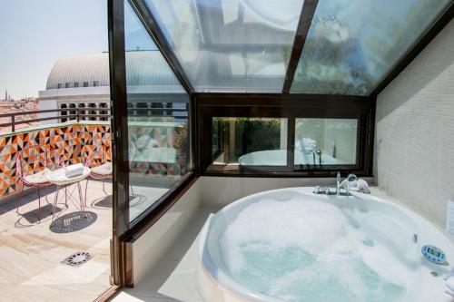 a bath tub in a room with a window at Hotel Opera in Madrid