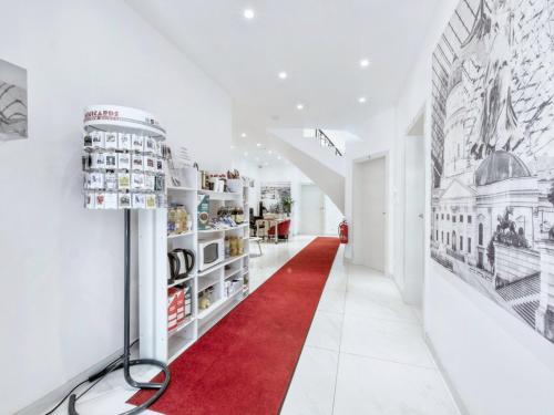 a red carpet in a white hallway with a red rug at Pension Amanda in Berlin