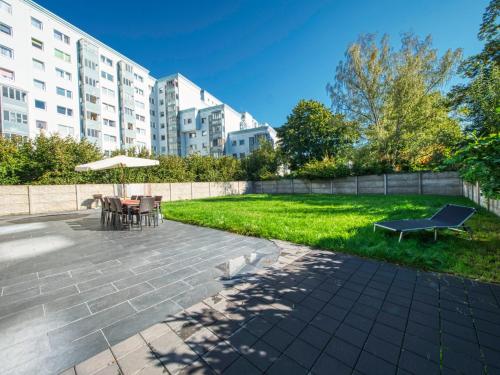 a patio with a table and a bench and an umbrella at Pension Amanda in Berlin