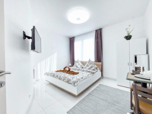 a white bedroom with a bed and a window at Pension Amanda in Berlin