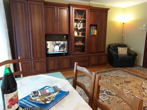 a living room with a dining table and a tv at Apartman Őri in Bük
