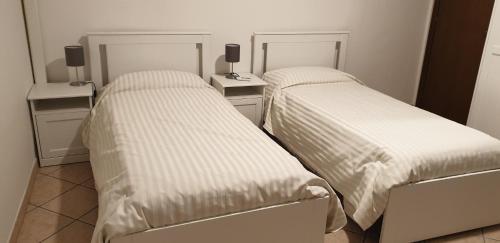two beds sitting next to each other in a room at Civico 54 - Locanda & Bistrò in Nonantola