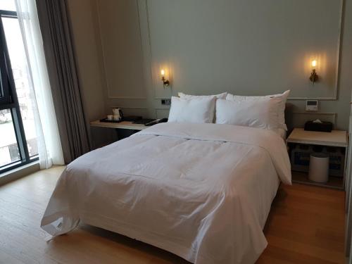 a large white bed in a hotel room at Hotel Libre in Siheung
