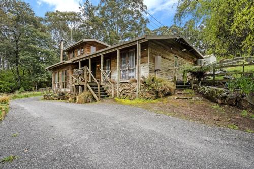 an old house with a road in front of it at Mole Creek Cabins in Mole Creek