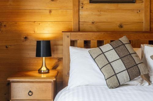 a bedroom with a bed with a lamp on a night stand at Mole Creek Cabins in Mole Creek