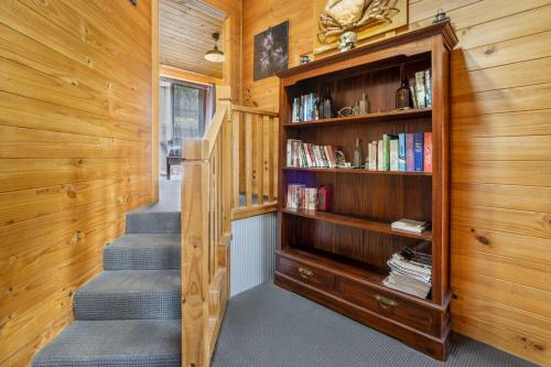 a staircase in a house with a book shelf at Mole Creek Cabins in Mole Creek