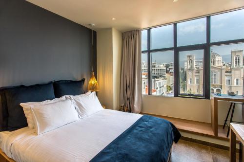 a hotel room with a bed and a large window at Ciel Living Athens in Athens