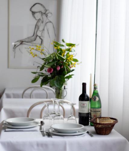 a table with a vase of flowers and two bottles of wine at Hotel Villa Belvedere in San Gimignano