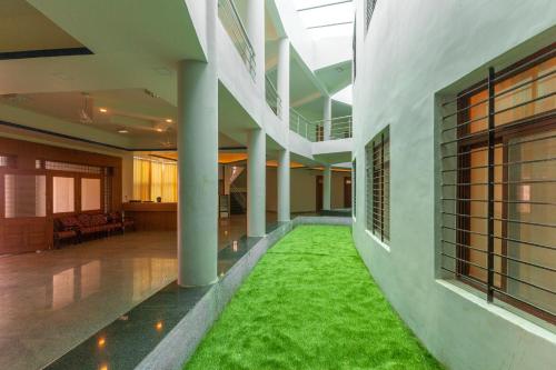 a hallway with a green rug in the middle of a building at KSTDC Hotel Mayura Krishna Almatti in Bāgalkot