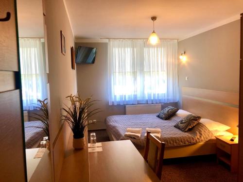 a small room with a bed and a table at Sosnowe Zacisze in Białystok