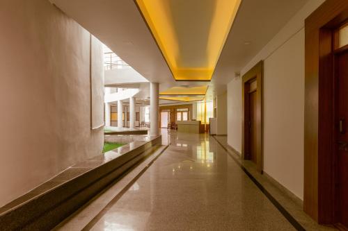 an empty hallway of a building with a yellow ceiling at KSTDC Hotel Mayura Krishna Almatti in Bāgalkot