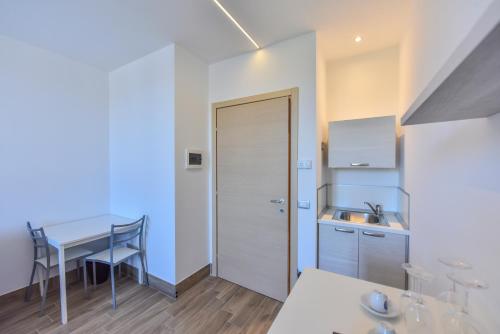 a kitchen with a table and a sink and a door at Happy Residence Milano Cesano Maderno in Cesano Maderno