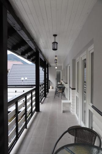 a balcony with chairs and tables on a building at Cazare Moldi Btt in Câmpulung Moldovenesc