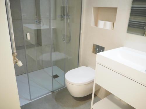 y baño con aseo y ducha acristalada. en Apartament modern a Girona centre, en Girona
