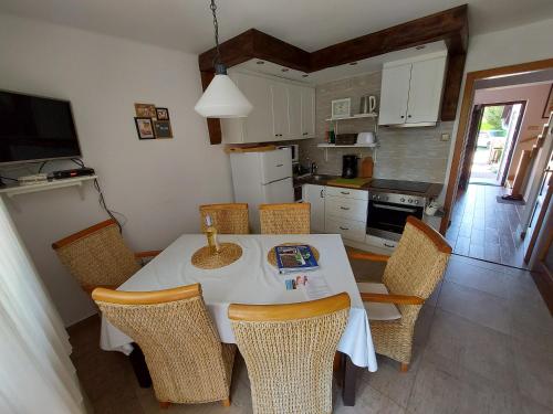 una cocina con mesa blanca y sillas y una cocina con en Apartman Őri, en Bük