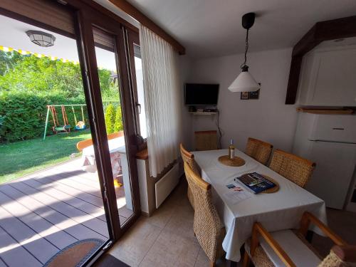 a dining room with a table and a sliding glass door at Apartman Őri in Bük
