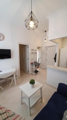 - un salon avec un canapé et une table dans l'établissement Encantador apartamento en el corazón de Sevilla, à Séville