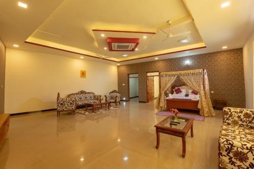 a living room with a bed and a table at KSTDC Hotel Mayura Krishna Almatti in Bāgalkot