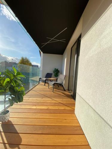 a balcony with a wooden floor and a table and chairs at Nova Apartamenty Rewa in Rewa