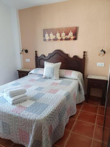 a bedroom with a bed with a quilt on it at Apartamentos Rurales Sierra Alta in Benaocaz