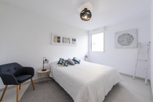 une chambre blanche avec un lit et une chaise dans l'établissement Elegance, à Nice