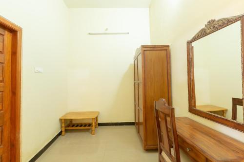 a dressing room with a mirror and a wooden stool at KSTDC Hotel Mayura Krishna Almatti in Bāgalkot