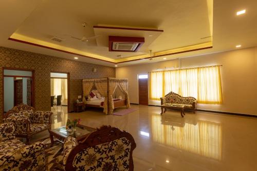 a living room with a couch and a bed at KSTDC Hotel Mayura Krishna Almatti in Bāgalkot