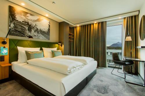 ein Hotelzimmer mit einem großen Bett und einem Fenster in der Unterkunft Motel One Salzburg-Süd in Salzburg