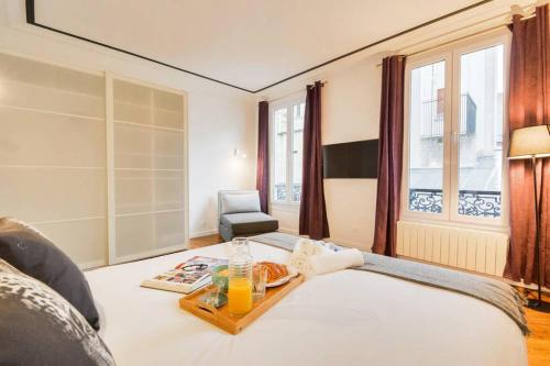 - une chambre avec un lit et un plateau de nourriture dans l'établissement Luxueux Duplex 6 - 8pers - Full Equipped - République, à Paris