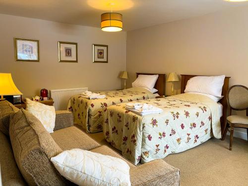 a hotel room with two beds and a couch at The Old Post House in Naseby