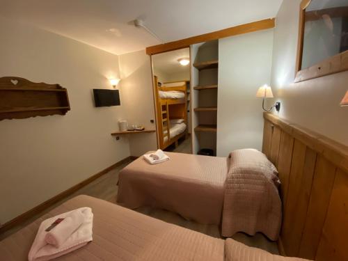 a small room with two beds and a mirror at Les Rhododendrons in Plagne 1800
