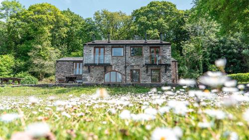 a stone house in the middle of a field of flowers at Hill Of Oaks in Windermere