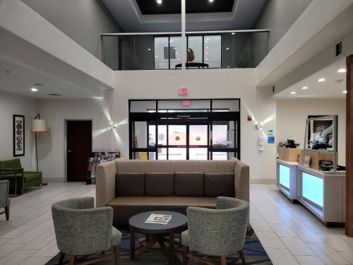 a lobby with a couch and chairs in a building at Holiday Inn Express Hotel & Suites Vidor South by IHG in Vidor