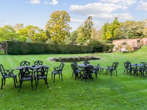 a group of tables and chairs in the grass at Secluded Mansion Retreat - Expansive Private Oasis - Pass the Keys in Burnham