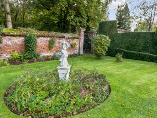 a garden with a statue in the grass at Secluded Mansion Retreat - Expansive Private Oasis - Pass the Keys in Burnham