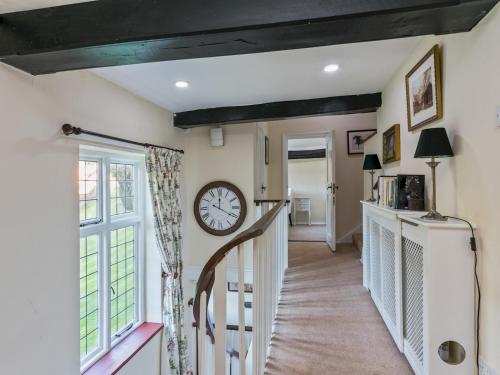 a stairway with a clock on the wall at Historically Charming Home with Large Garden- Pass the Keys in Burnham