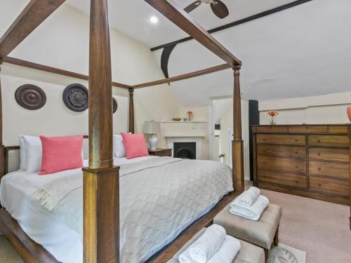 a bedroom with a four poster bed and a fireplace at Historically Charming Home with Large Garden- Pass the Keys in Burnham