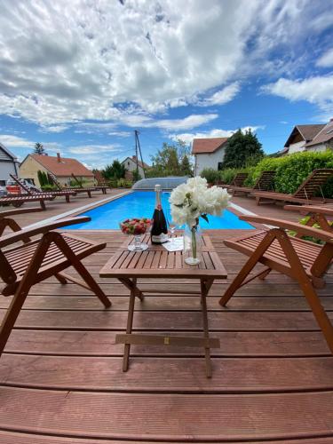 a picnic table with flowers on a deck with a pool at Mandula Villa in Tihany