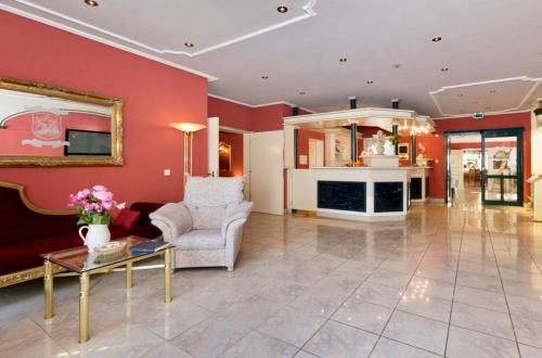 un soggiorno con pareti rosse, divano e tavolo di Parkhotel a Dallgow
