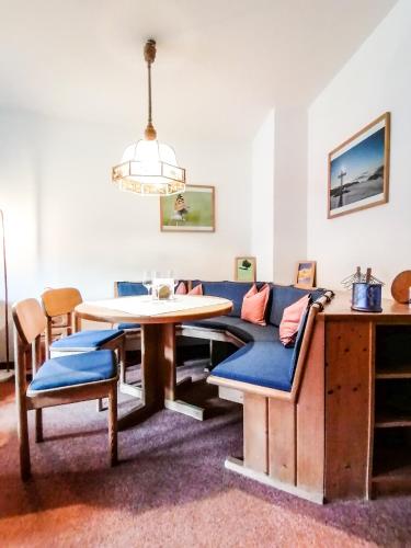 a living room with a blue couch and a table at Haus am Römerbad in Bad Kleinkirchheim